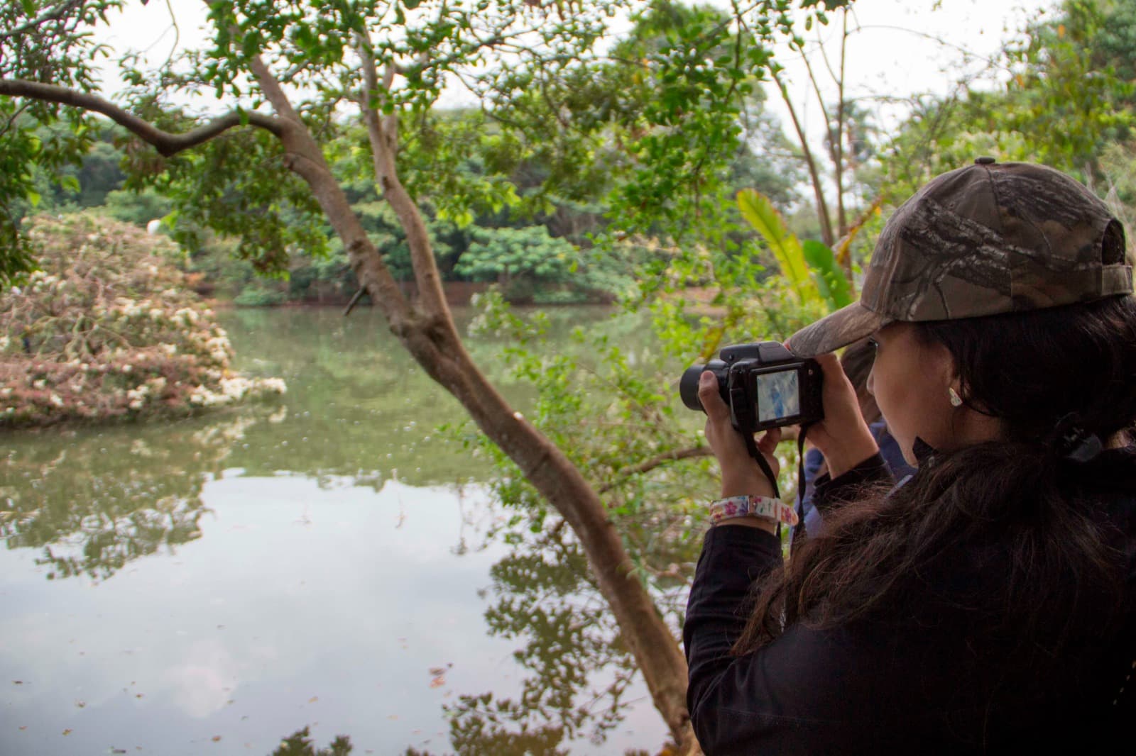 Joven fotografiando la biodiversidad de una laguna